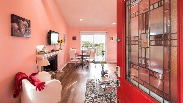 A cozy living room with a fireplace, a dining area, and a red door. - View, 1 King bed & sleeper; .33 mi to Barton Springs/Zilker Park, @2 mi to DT! (Austin)