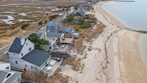 Zona residencial à beira-mar, com casas em frente a uma praia de areia.