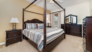 A four-poster canopy bed with a wooden frame, a nightstand with a lamp, a dresser, and a mirror. - Serene Pool Home Overlooking Conservation Area 🌳🏊‍♂️ (Davenport)
