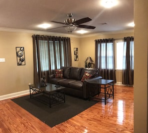 Relax in this stylish living room with a comfortable sofa, coffee table, and ceiling fan.