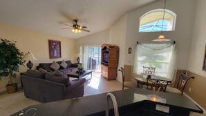 A spacious living area with a sofa, a dining table, and a kitchen area.