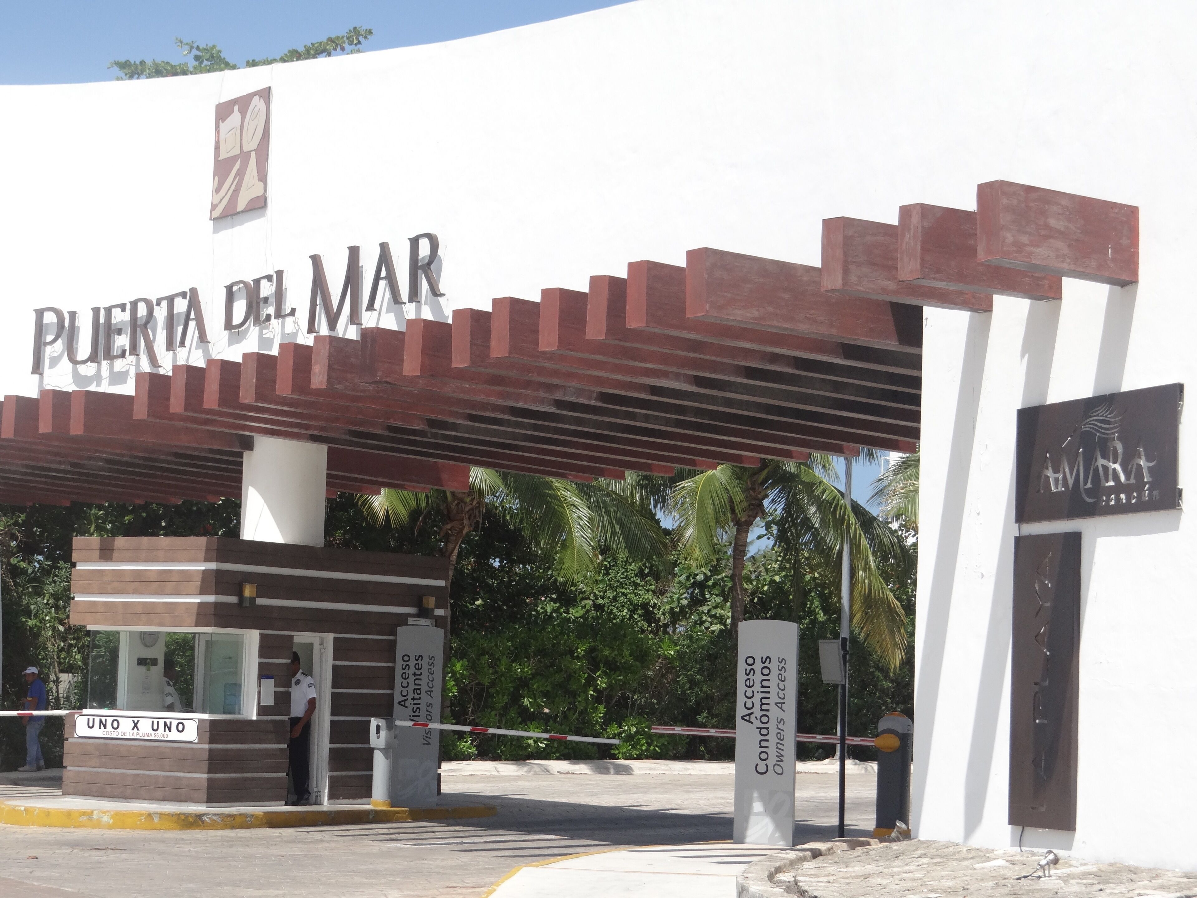 A gated entrance with a sign reading "Puerta del Mar" and "Access Condominiums Owners Access".