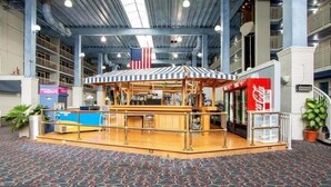 A bar area with a striped canopy and an American flag, surrounded by bookshelves and a Coca-Cola vending machine. - Oceanfront and Bay view at the Carousel with indoor pool (ocean city)