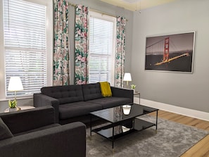 A modern living room with a sofa, coffee table, and two lamps.
