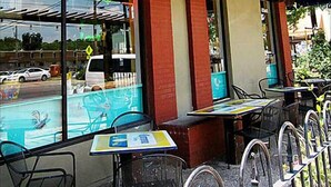 Il caffè di Julio con posti a sedere all'aperto e una veranda coperta.