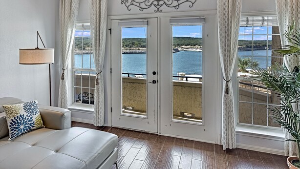 Una habitación con cama, ventana y vista al mar, además de un adorno en la pared.