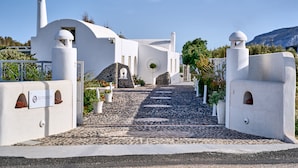 A white building with a stone pathway leading to the entrance. - La Maison Villa with Large Private Pool - Accommodates 10 (SANTORINI)