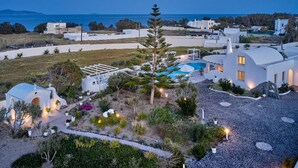 A coastal property with a swimming pool, white buildings, and a small chapel. - La Maison Villa with Large Private Pool - Accommodates 10 (SANTORINI)