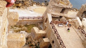 Una maqueta de una antigua construcción de piedra con vista al mar.
