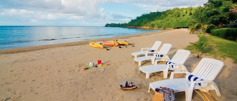 Een privéstrand, ligstoelen aan het strand, strandlakens