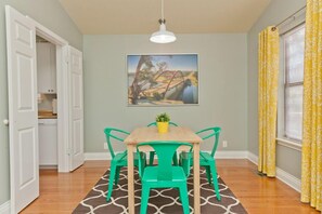 Enjoy meals in this cozy dining area with a table, chairs, and a potted plant.