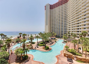 Enjoy a refreshing swim in the hotel's central pool surrounded by palm trees and a paved walkway.
