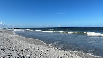 Na praia, espreguiçadeiras, toalhas de praia