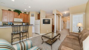 A spacious living area with a kitchen, a dining area, and a seating area with a sofa and chairs.