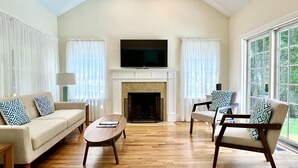 A living room with a fireplace, a television, and a large window. - Prime East Hampton Village Location. Heated Pool.  Walk To All!  (East Hampton)