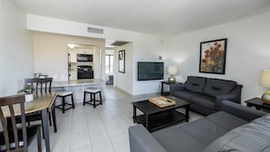 A modern living room with a sofa, coffee table, and dining area. - 120 Living in Ultimate Comfort | Pool, Lounge & Full Kitchen Suite! (Scottsdale)
