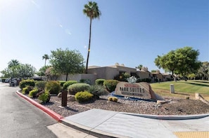 Señal de Scottsdale Park Suites con un área ajardinada al frente.