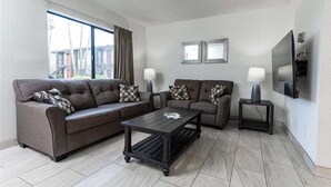 Ein Wohnzimmer mit zwei Sofas, einem Couchtisch und einem Fernseher.
