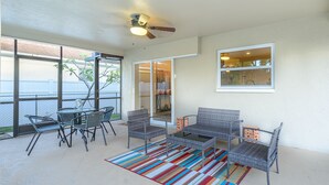 An outdoor patio with wicker furniture, a colorful striped rug, and a ceiling fan. - ★Private 5 Star Pool Home: 5 min to Beach★ (Naples)