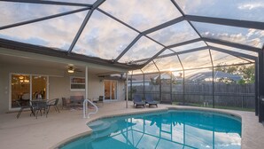 A covered outdoor swimming pool with a glass ceiling, patio seating, and a view of the backyard. - ★Private 5 Star Pool Home: 5 min to Beach★ (Naples)