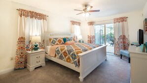 A bedroom with a bed, nightstands, a ceiling fan, and a view of the outdoors. - ★Private 5 Star Pool Home: 5 min to Beach★ (Naples)