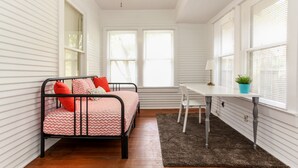 Een kamer met een bed, een bureau en een raam.