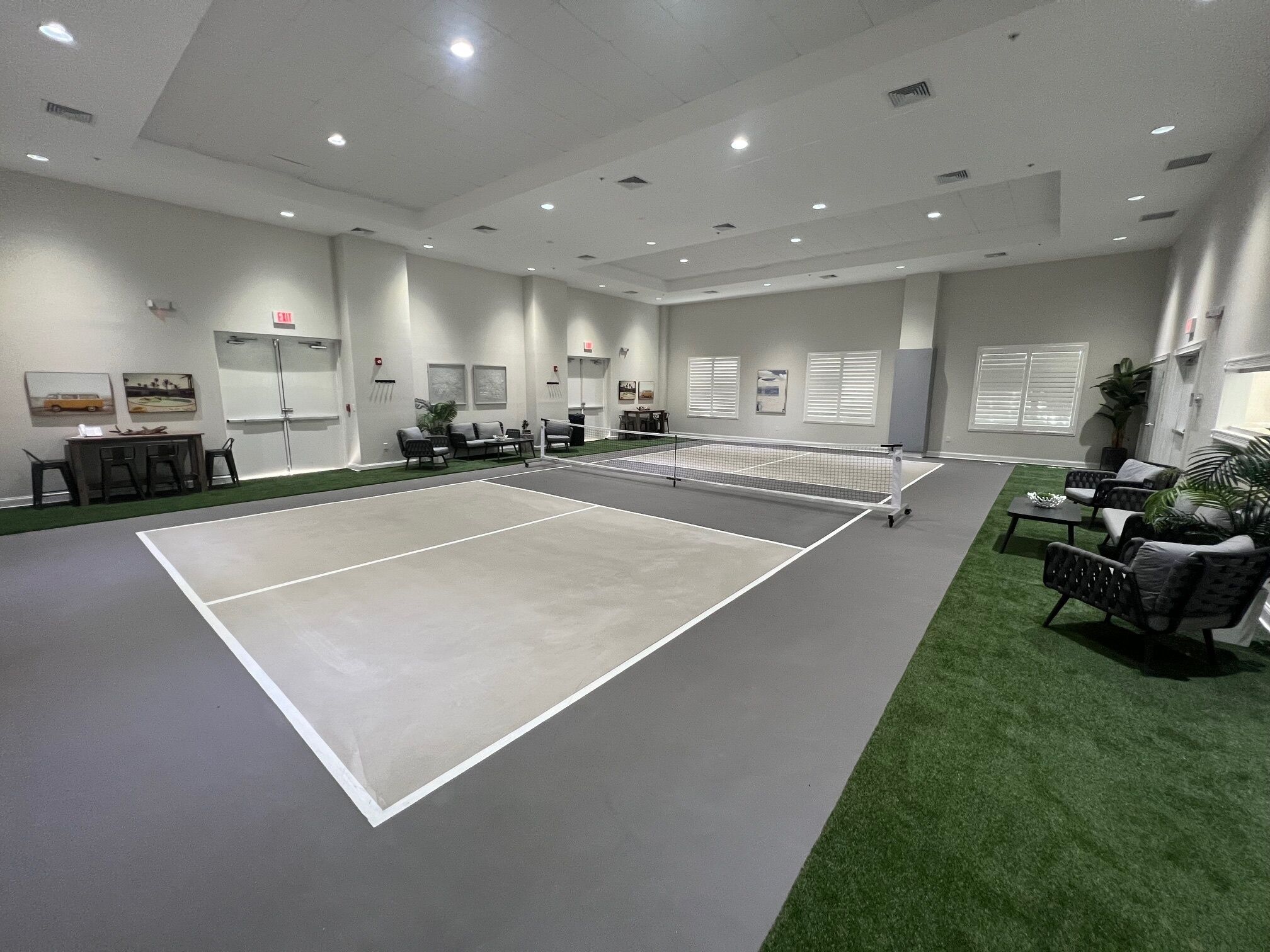 Un court de tennis avec des sièges et un tableau blanc fixé au mur.