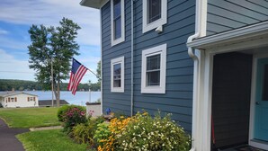 A residential house with a front yard, a small pond, and an American flag. - 5 minutes to Peek n Peak, ON SITE PRIVATE HOT TUB, Large private yard (Clymer)