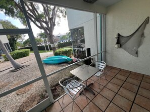 Un patio con mesa y sillas, una hamaca y vistas al exterior.