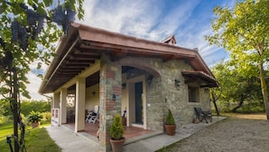 A stone house with a covered porch, a gravel driveway, and potted plants. - Villa in Toscana - Reggello con Piscina, Wi-Fi, Giardini.  (Reggello)