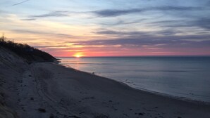 Een strand met een ondergaande zon aan de horizon.