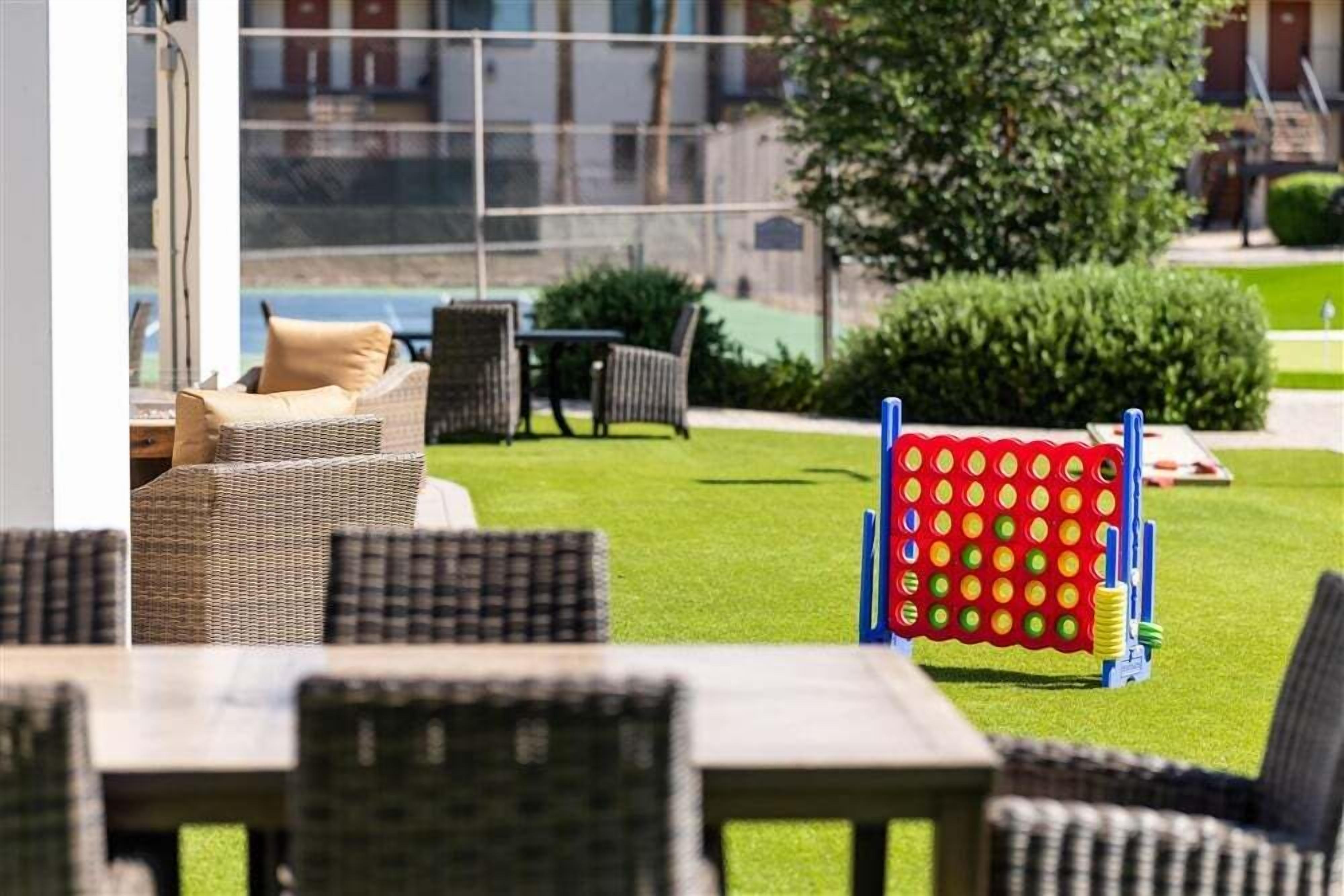 A patio area with wicker furniture, a pool table, and a colorful play structure.