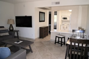 Cozy living space with a flat-screen TV, comfortable sofa, and dining area.