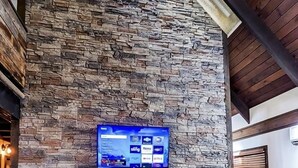 A stone fireplace with a flat-screen TV mounted above it.