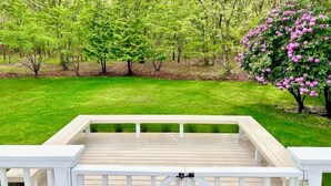 Eine Terrasse mit Blick auf einen gepflegten Rasen und Bäume.