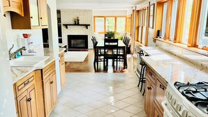 A spacious kitchen with a central island, wooden cabinets, and a large stove.