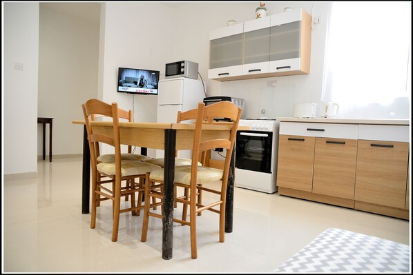 Enjoy meals at the dining table with a TV for entertainment.