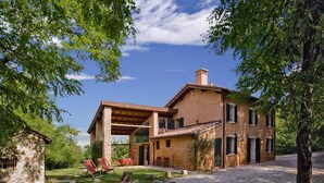 A rustic stone building with a covered patio and outdoor seating.