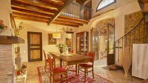 A dining area with a wooden table and chairs, a red rug, and a stone fireplace. - Villa with splendid pool near the beaches, 4 bedrooms (Marinella di Selinunte)