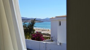 A coastal view from a balcony with a clear sky, a beach, and distant mountains. - Apartment  WITH SEA VIEWS and excelent location - IDEAL FOR FAMILIES (Costa Calma)
