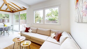 Un salon moderne avec un canapé, une table à manger et une grande fenêtre.