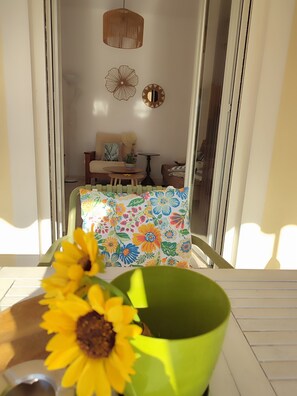 Une pièce comprenant une table, un canapé, un mur décoratif et une fenêtre.