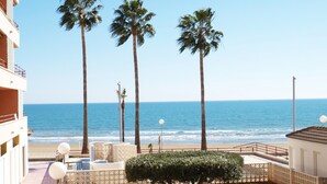 A balcony with a view of the ocean, palm trees, and a small garden area. - ApartUP La Concha Beachfront I (Oropesa del Mar)