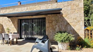 A stone exterior with a covered patio, outdoor seating, and a view of the surrounding landscape. - Superb villa in Porto-vecchio  (Porto-Vecchio)
