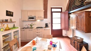A kitchen with white cabinets, a microwave, a sink, and a window with a view.