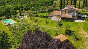 Una casa con piscina, jardín y viñedo.