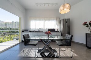 A modern kitchen with a glass dining table, stainless steel appliances, and a view of greenery outside. - Holidays & Health in Finca Oasis - Villa 7 by Viilas Rivero (Telde)