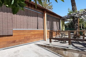A patio area with a wooden fence, a table, and chairs. - Holidays & Health in Finca Oasis - Villa 7 by Viilas Rivero (Telde)