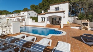A pool area with white lounge chairs, a small pool, and a patio with a grill. - Olalla: Villa with private pool in L'Escala (L'Escala)