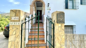 Ein Hauseingang mit einem Steintor mit der Aufschrift 'CASA NURIA', einer gefliesten Treppe und einem Briefkasten.